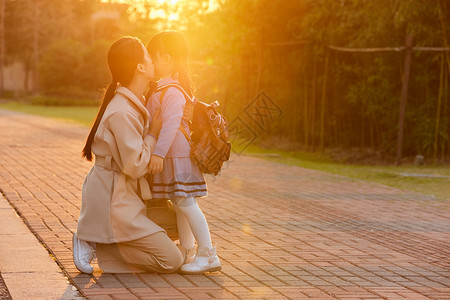 夕阳下妈妈亲吻女儿图片