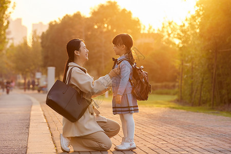 秋冬衣服夕阳下妈妈为女儿整理衣服背景