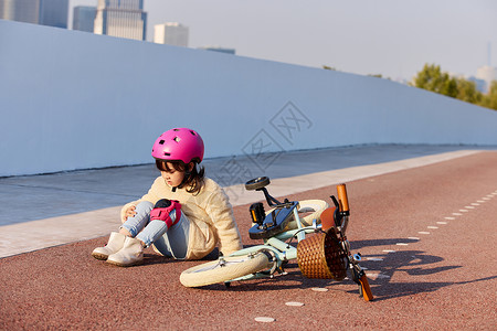 骑车游玩的女孩小女孩骑车摔倒受伤背景