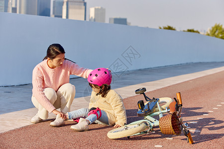 骑车赏荷的女孩妈妈检查女儿骑车摔倒的伤势背景