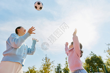 手绘踢足球的人妈妈陪女儿户外玩耍踢足球背景