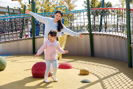 妈妈和女儿的亲子时光妈妈陪女儿公园娱乐设施玩耍背景