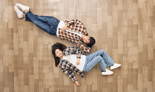 躺着情侣创意俯拍青年情侣躺在地板上放松背景