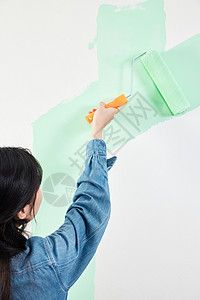 青年女性室内粉刷装修墙面背影图片