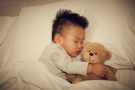 躺在床上抱着公仔睡觉的宝宝高清图片