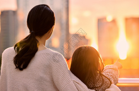 坐热气球孩子看夕阳的母女背影背景