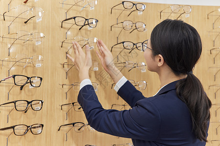 眼镜店工作人员整理架子上的货品图片