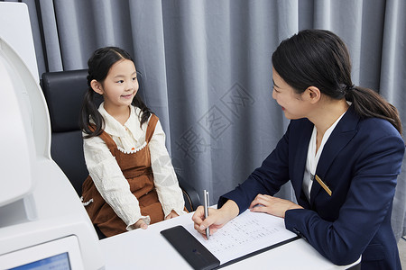 验光师耐心询问女孩的视力状况背景图片