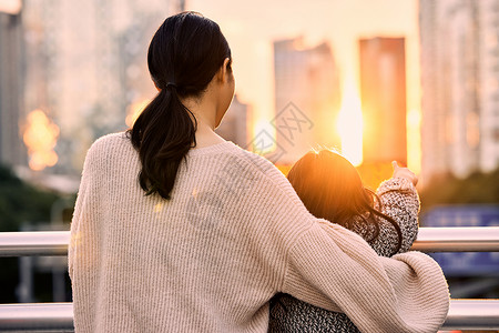 坐着母女背影夕阳下母女站在天桥上的背影背景