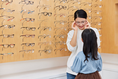 妈妈带孩子到眼镜店挑选合适的眼镜高清图片