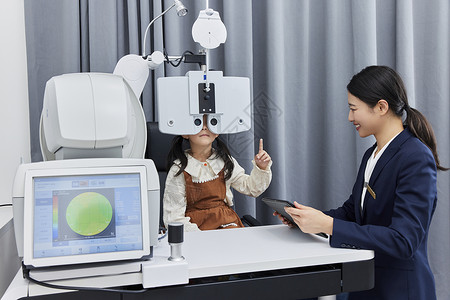 正在验光机器上检查视力的小女孩图片