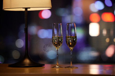 灯桶摆放在桌子上的两杯香槟酒背景