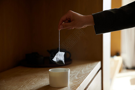 中式台面往茶杯里放茶包手部特写背景