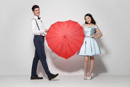 打开雨伞浪漫情侣与爱心伞背景