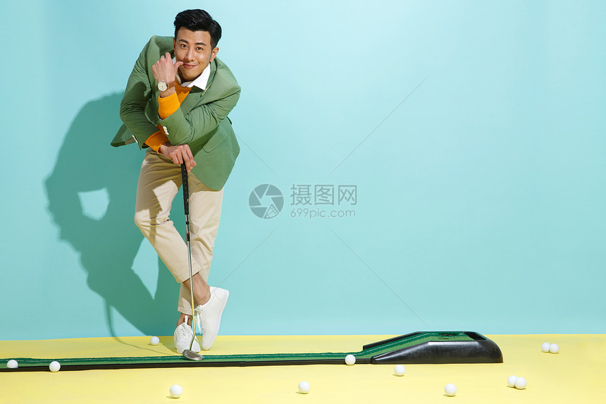 做鬼脸有趣的办公室职员青年男人打高尔夫球图片