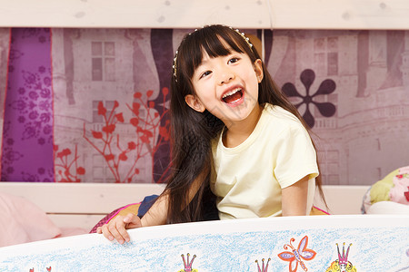 被子卡通可爱的小女孩在床上玩耍背景