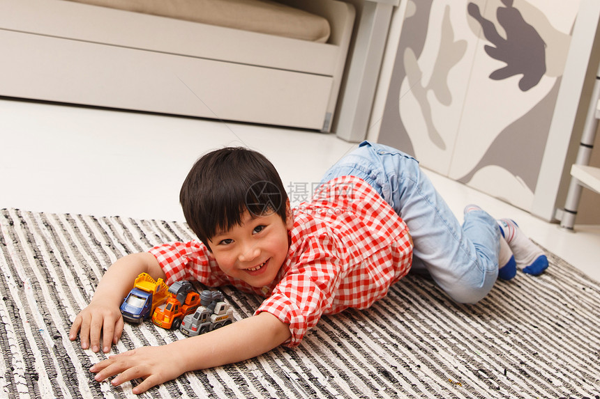 可爱卧室小男孩在地毯上玩耍图片