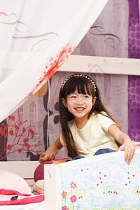 被子卡通可爱的小女孩在床上玩耍背景