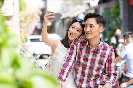 街道快乐情侣用手机自拍高清图片