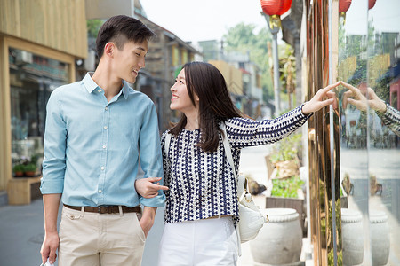 伸手指女人青年情侣逛街购物背景图片