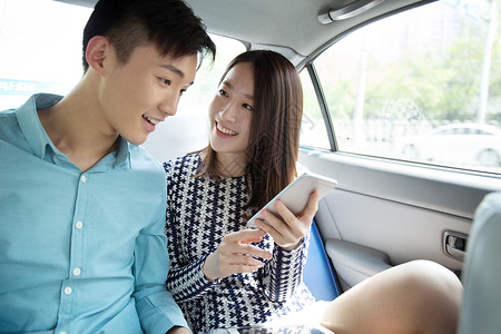 快乐青年情侣在车内看手机高清图片