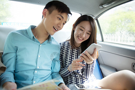 爱的旅途青年情侣在车内看手机背景