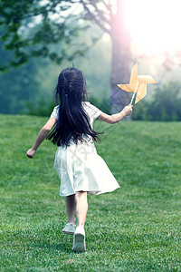 幸福小女孩在草地上玩耍高清图片