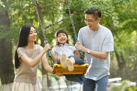 家庭生活相伴东方人快乐的一家三口荡秋千图片