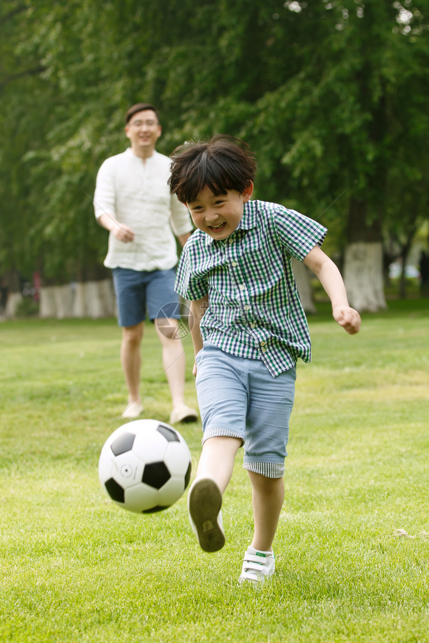 快乐父子在草地上踢足球图片