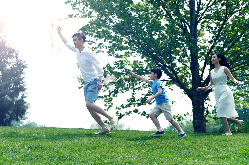 高兴学龄前儿童成年人一家三口在草地上放风筝图片