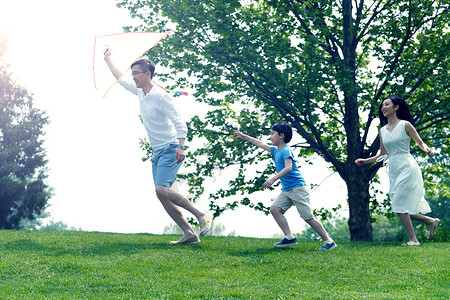 高兴学龄前儿童成年人一家三口在草地上放风筝图片