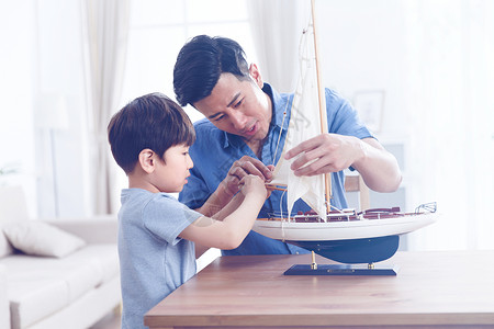 小男孩与帆船快乐的父子在客厅玩耍背景