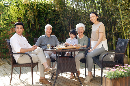 快乐幸福家庭在院子里喝茶高清图片