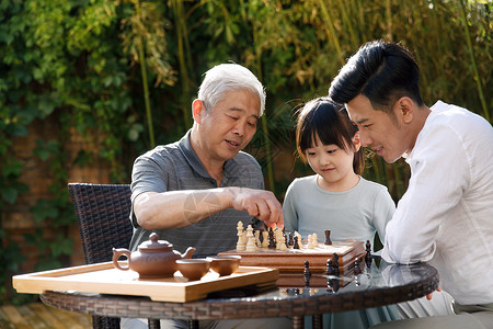 下棋的女孩祖孙三代在庭院里下棋背景