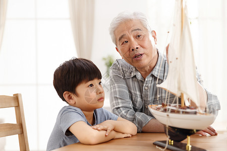 可爱帆船交通方式家庭幸福祖父和孙子在客厅玩耍背景