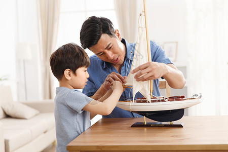 帆船模型快乐的父子在客厅玩耍背景