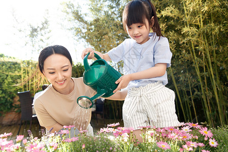 盆栽浇水年轻的母亲和女儿在浇花背景