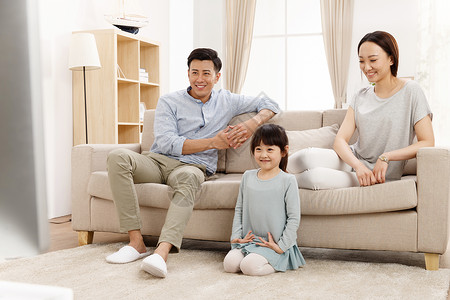 双亲家庭满意相伴幸福的一家三口在客厅看电视图片