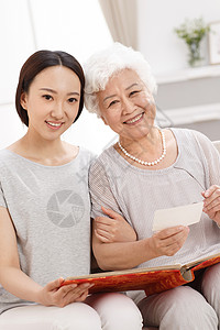 爱在母亲节字体成年子女休闲装女人幸福快乐的母女在看照片背景