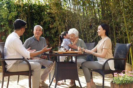 幸福家庭在院子里喝茶高清图片