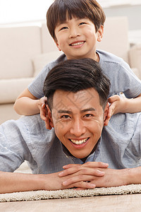 两个人趴着彩色图片快乐的父子在客厅玩耍高清图片