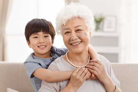 家庭生活老年女人兴奋可爱的小男孩和祖母在客厅图片