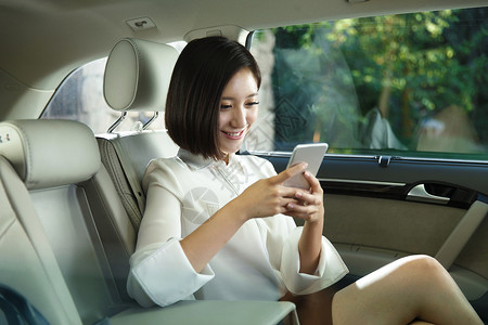 青年女人坐在汽车里使用手机图片