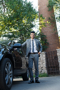 成功人士青年男人站在汽车旁边图片
