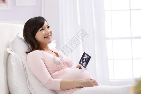 时尚东亚生长孕妇拿着超声波照片高清图片