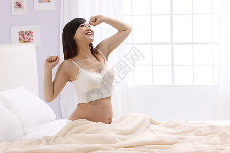 摄影侧面视角希望孕妇起床伸懒腰高清图片