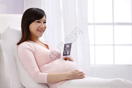新生活放松仅女人孕妇拿着超声波照片高清图片
