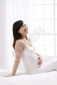 休息女人快乐孕妇坐在床上图片