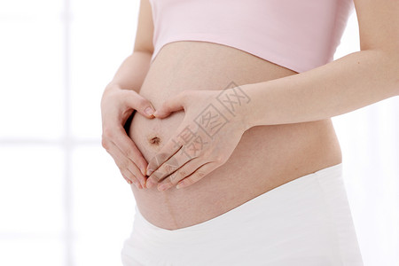 孕妇安全裤孕育彩色图片皮肤孕妇在肚子上做心形手势背景