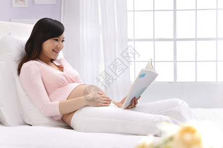 学习新条例身体保养侧面视角爱孕妇坐在床上看书背景
